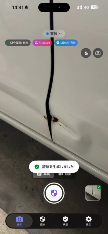 白い車のドアに深いへこみと錆が見られ、損傷状況を示している。画面上には事故報告用のアプリインターフェースが表示されており、「証跡を生成しました」というメッセージが見える。