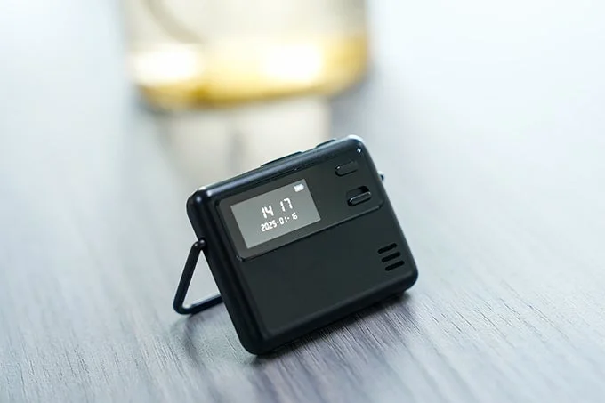 時刻と日付が表示された小型の黒いデジタルデバイス