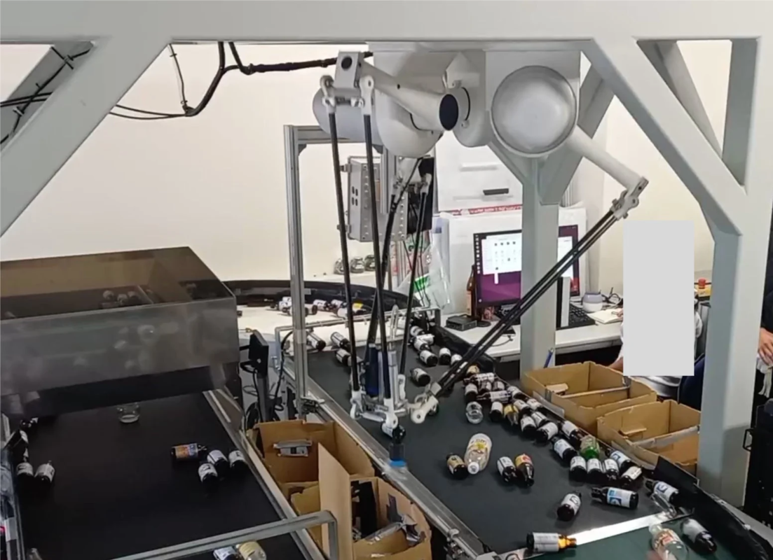 ロボットアームがボトルを仕分ける様子