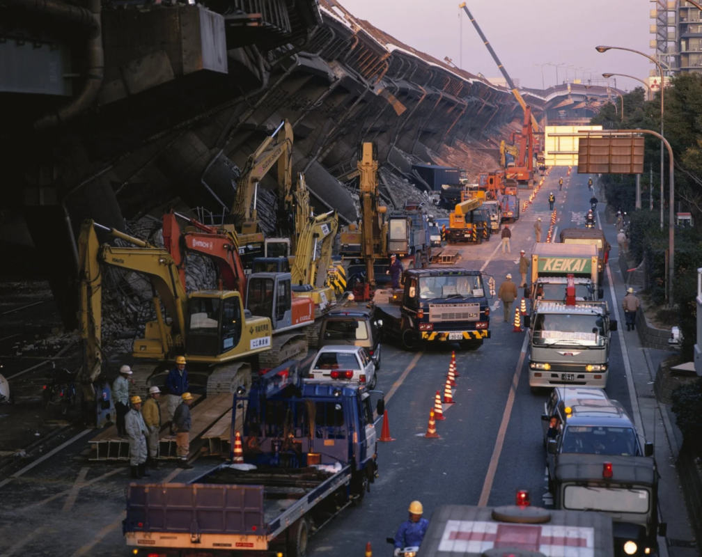 地震により倒壊した高速道路の現場で復旧作業にあたる重機と作業員
