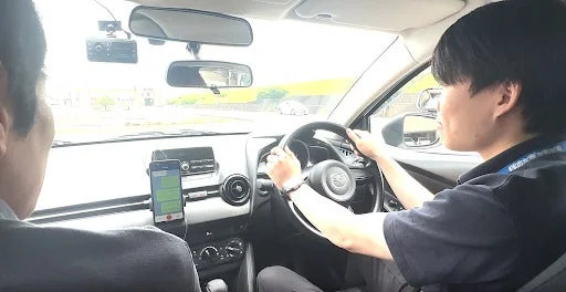 車内から撮影された画像で、運転席と助手席に人物