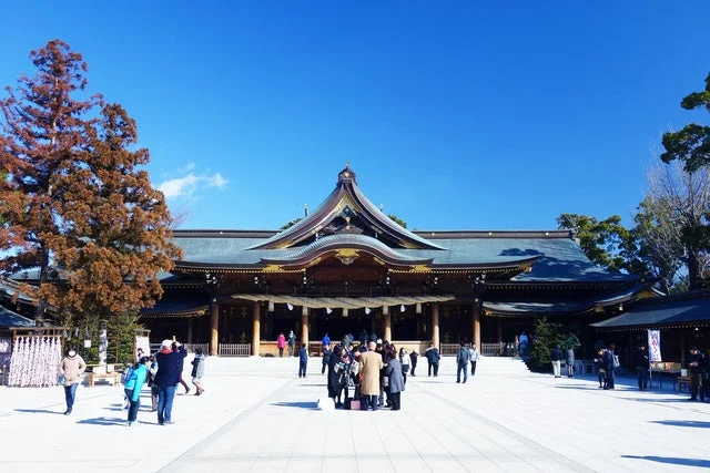 青空の下、多くの参拝客で賑わう日本の神社の広大な境内