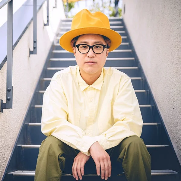 黄色い帽子と眼鏡をかけた北沢直樹氏のポートレート