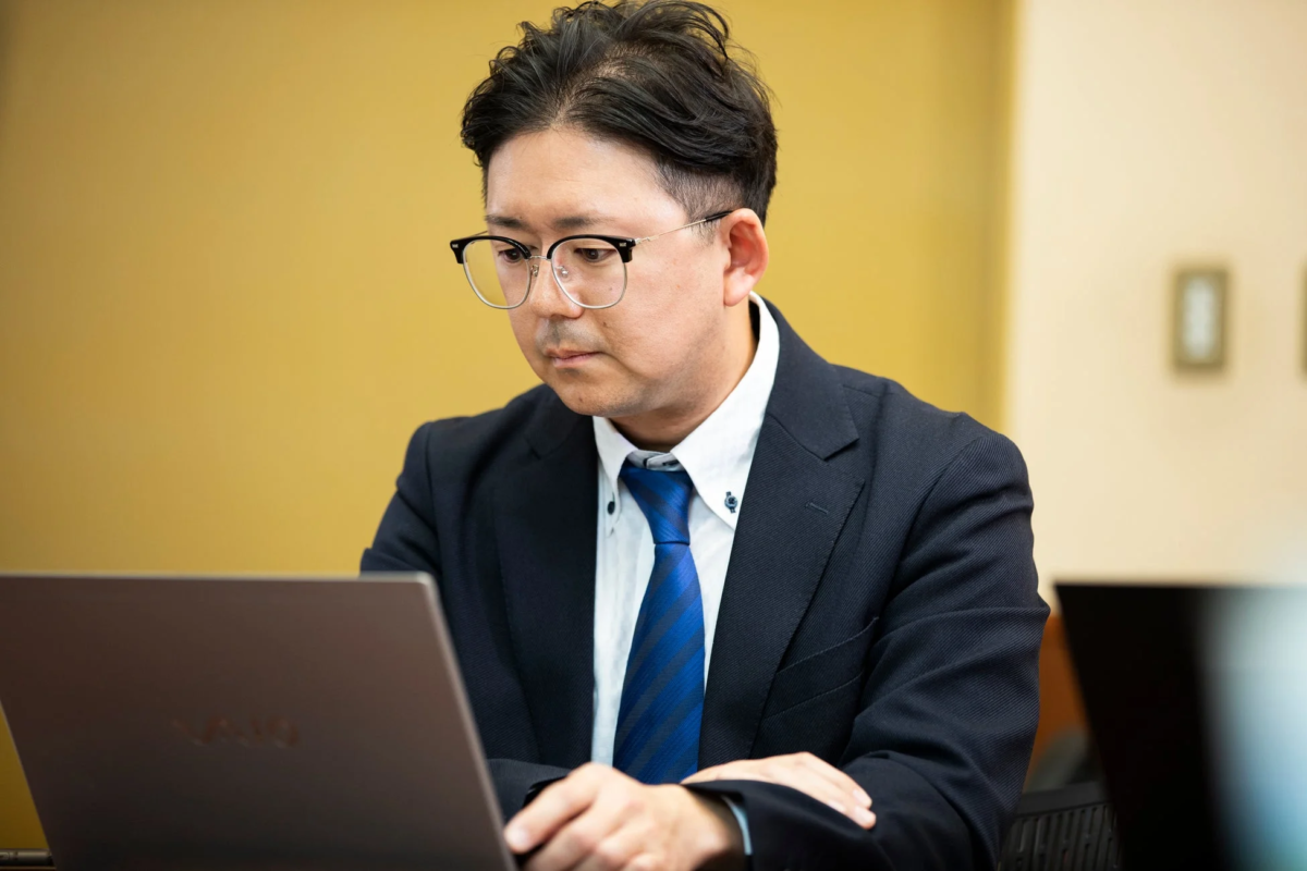 ノートパソコンを見る男性