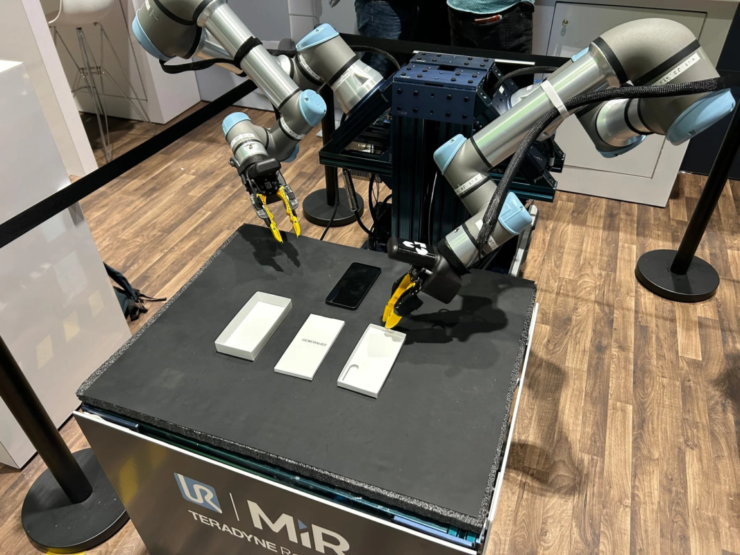 複数のロボットアームがスマートフォンとそのパッケージを扱う様子を捉えた画像