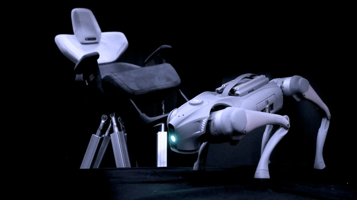 前景には、目が光る四足歩行の犬型ロボットが写っています。後景には、ぼやけた医療用または歯科用の椅子が見え、全体的に暗い背景の中で未来的な技術と医療の融合を示唆しています。