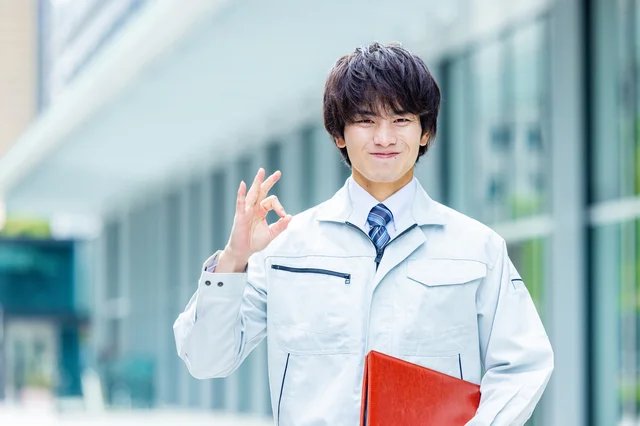 作業着姿の若い男性がOKサイン