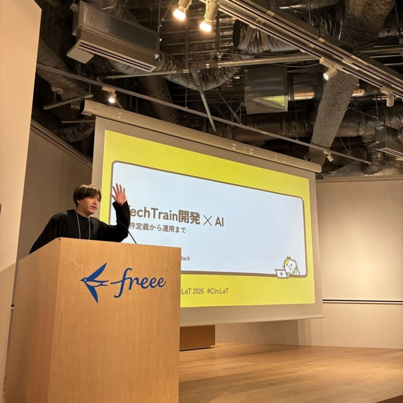 freeeのロゴが入った演台で、一人の男性がスクリーンを背にプレゼンテーションを行っています