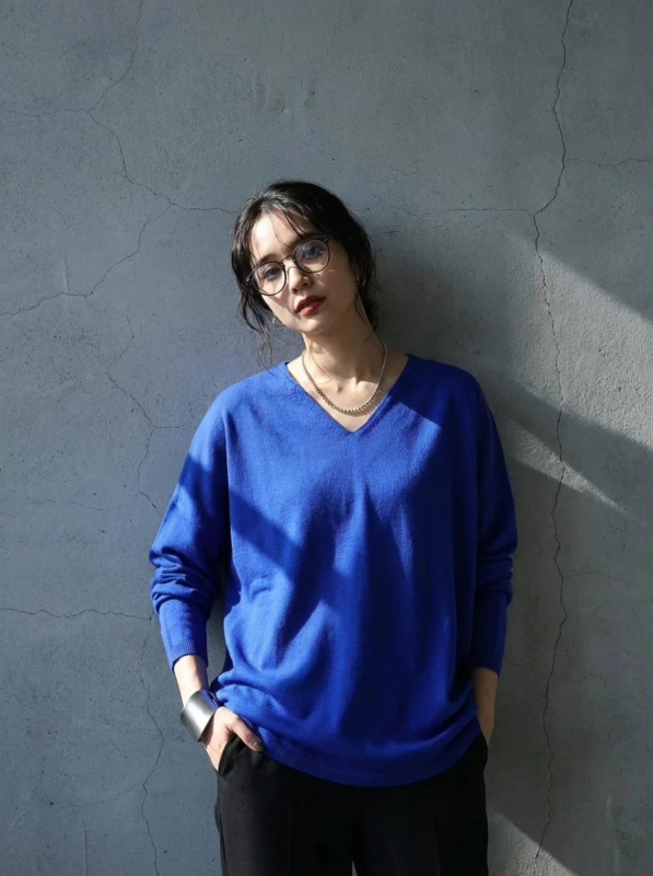 女性,ファッション,青いセーター,Vネック,メガネ,ネックレス,バングル,コンクリート壁,ポートレート,私服,日差し,影