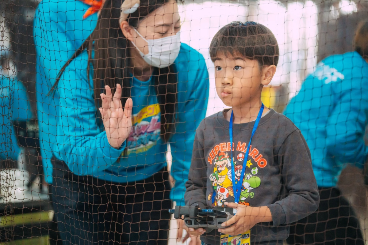 ドローン飛行体験で操作する子ども