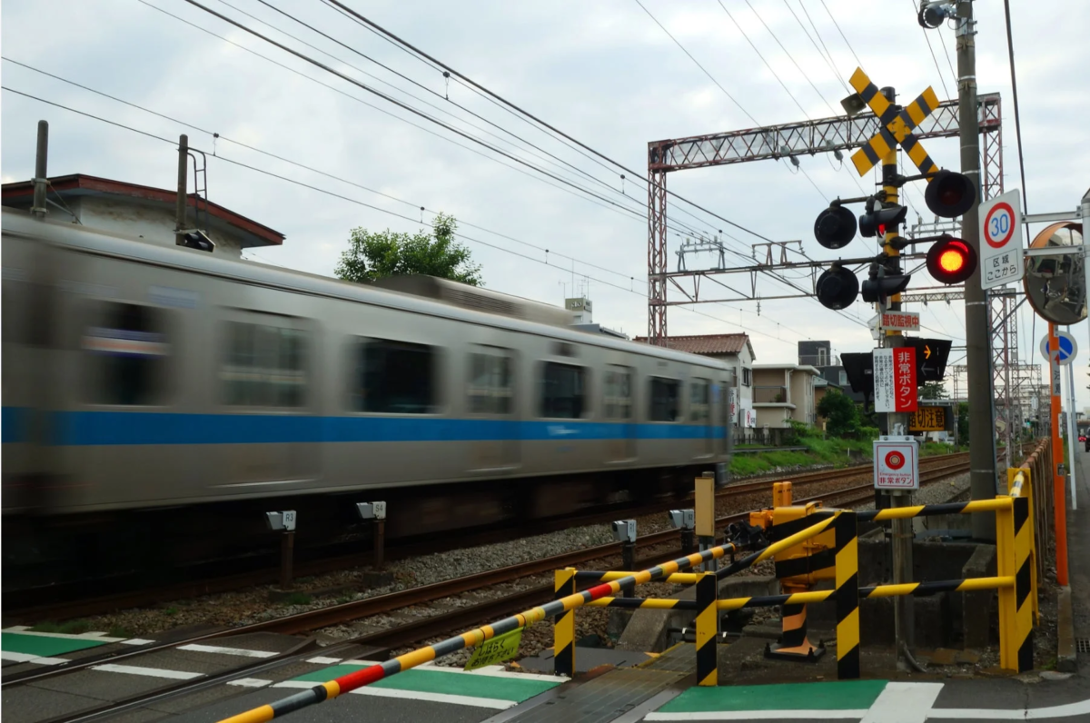 電車が日本の踏切を通過している瞬間を捉えた写真