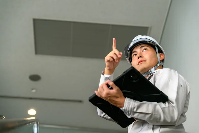 建設現場でタブレットを操作する作業員