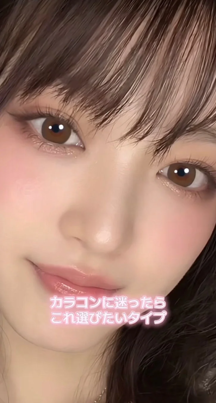 女性の顔のクローズアップで、ブラウンの瞳とピンク系のメイクが特徴的
