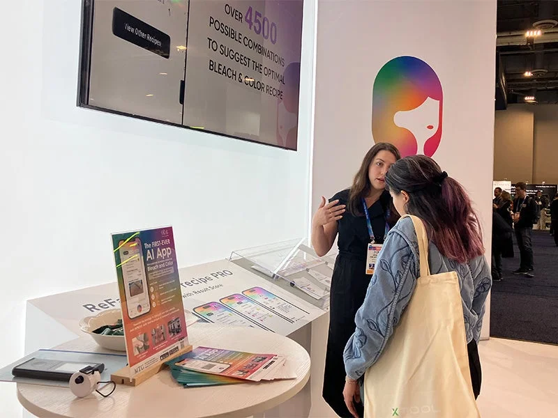 展示会ブースでAIアプリについて説明する女性
