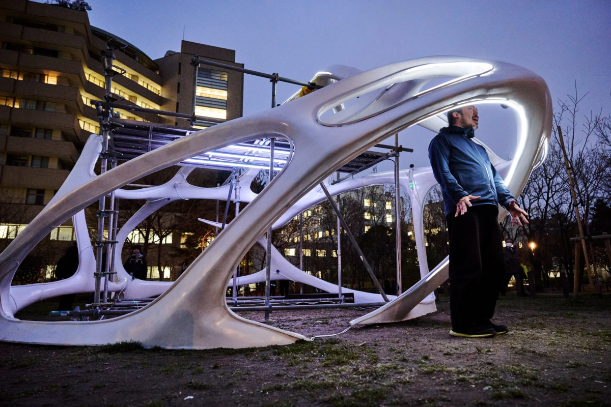 夜の屋外に設置された曲線的な光るアートインスタレーション