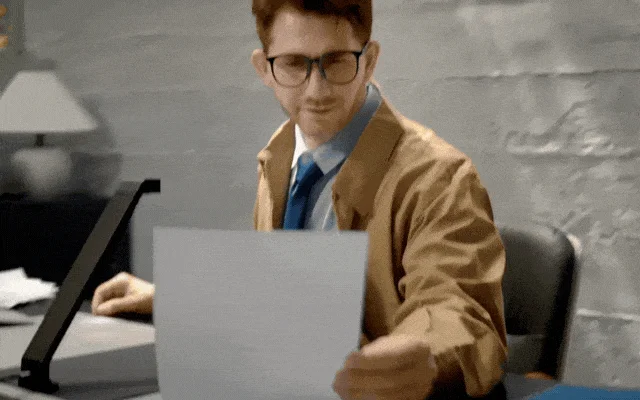 デスクで書類をスキャンする男性