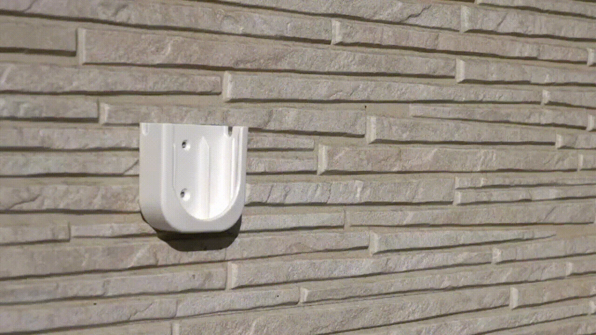 白いU字型のブラケットが取り付けられた石積みの壁