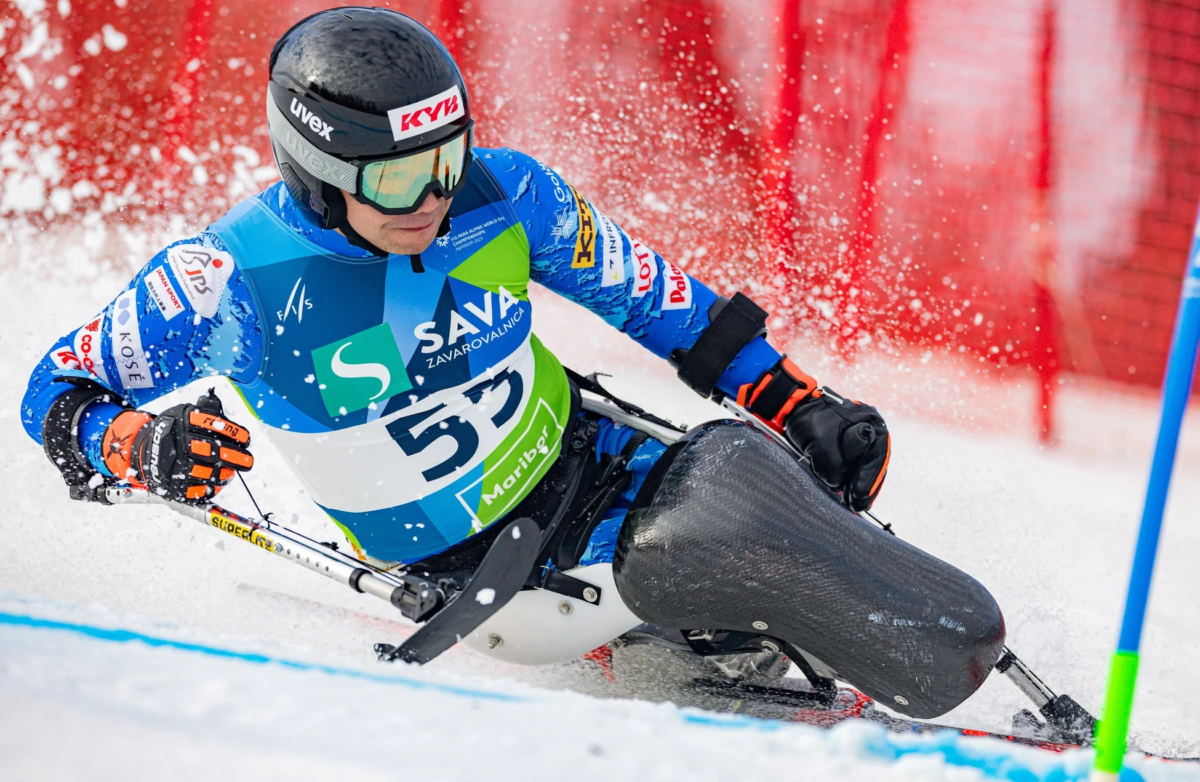 チェアスキーの選手が雪しぶきを上げながら滑走する写真