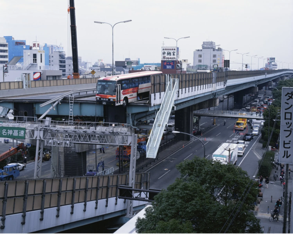 高架道路からバスがはみ出し、その前部が宙に浮いている状況