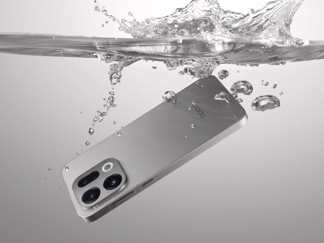 銀色のスマートフォンが水中に沈められ、水しぶきや泡が周囲に飛び散っている様子を捉えた画像