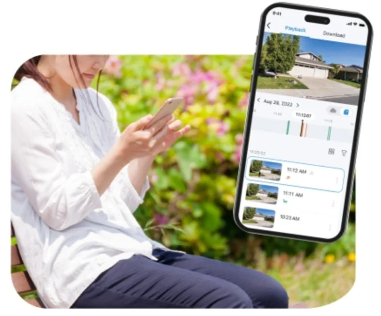 スマートフォンで防犯カメラの映像を確認する女性