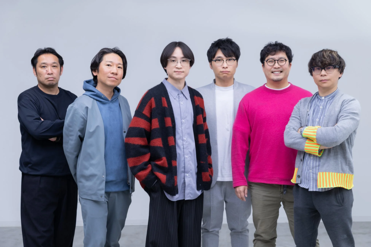 白い背景の前で並んで立つ6人の男性