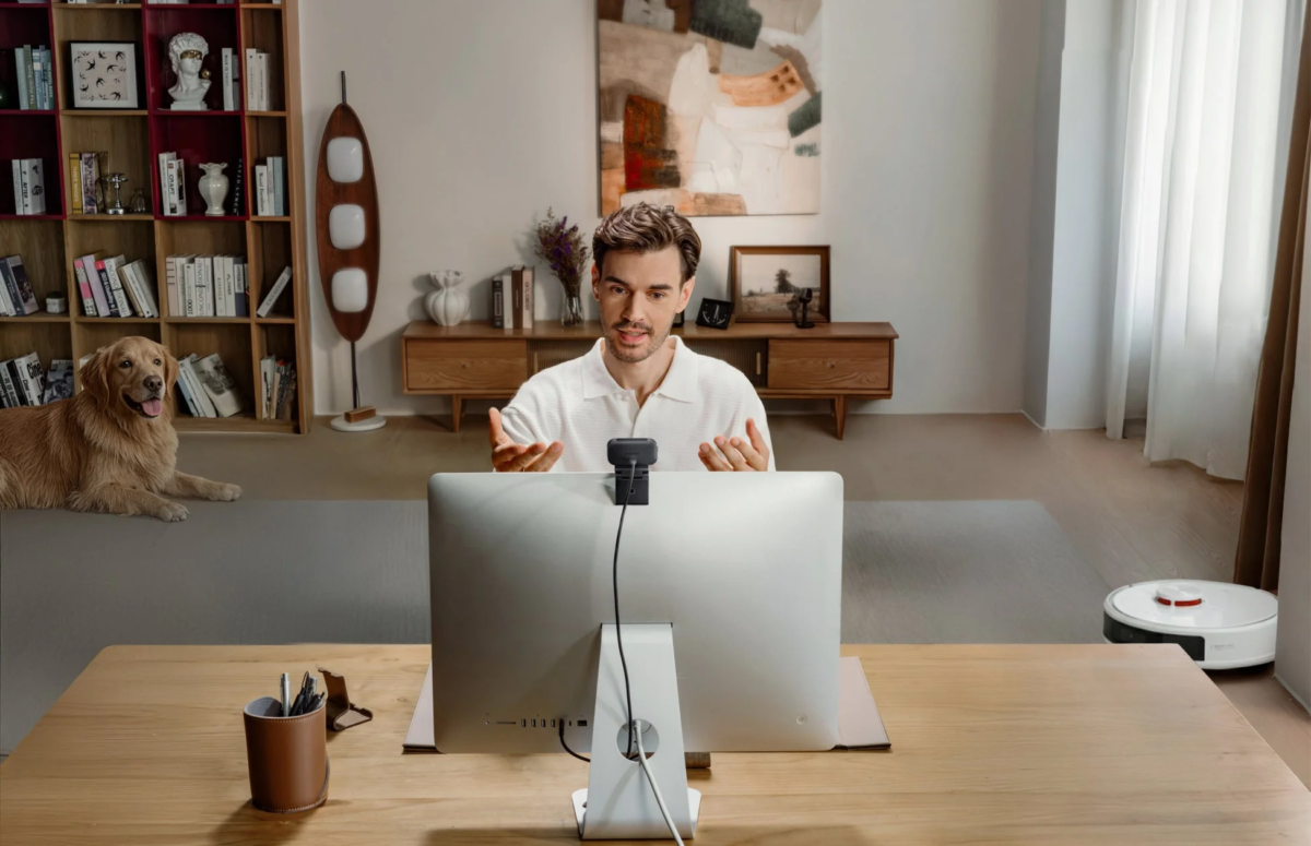 在宅勤務でウェブカメラを使う男性と犬