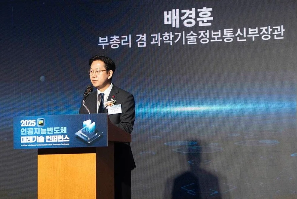 韓国のペ・ギョンフン副総理兼科学技術情報通信部長官が「2025人工知能半導体未来技術カンファレンス」で演説している様子です。壇上でマイクに向かって話す男性の姿が捉えられています。