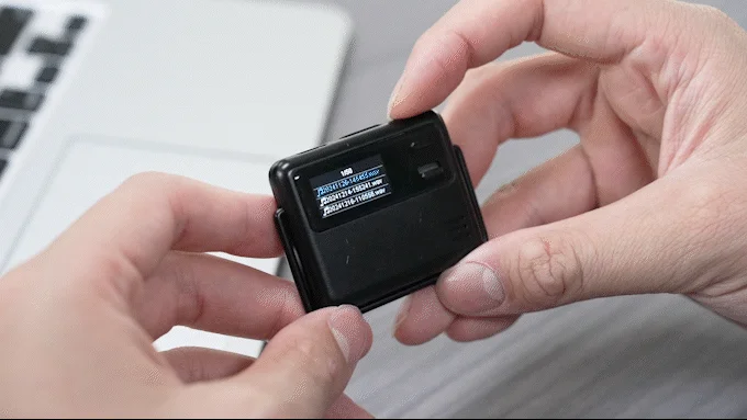 男性が小型の黒いデジタルレコーダーを両手で操作している