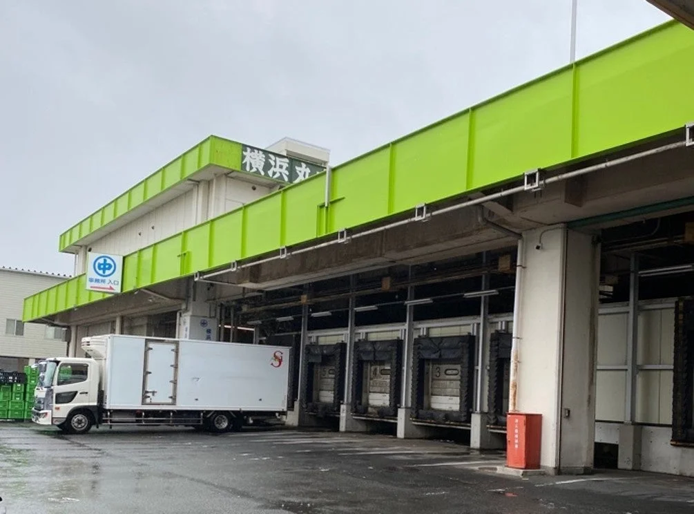 横浜丸と書かれた建物とトラックが停車する荷積みドック