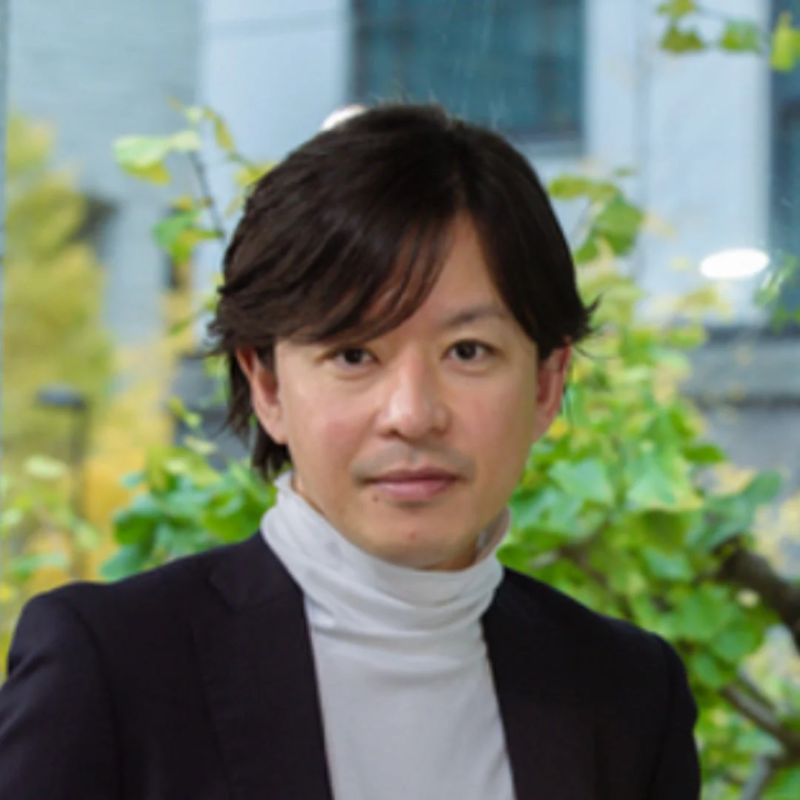 白いタートルネックと黒いジャケットを着用した山田兼司氏のポートレート