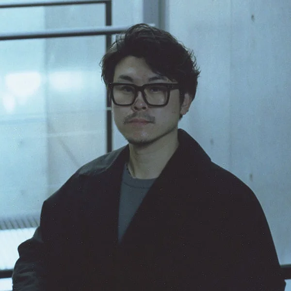 黒縁メガネをかけた小杉幸一氏のポートレート