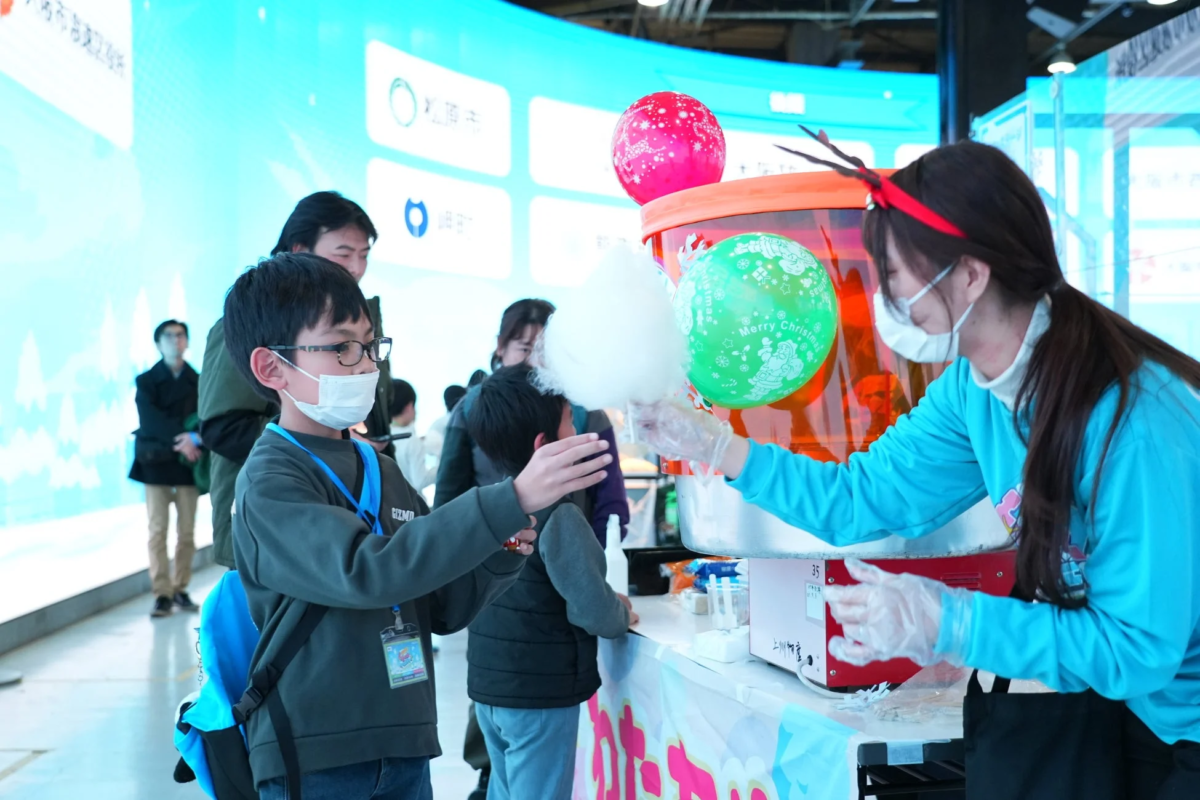 縁日ブースで綿菓子を受け取る子ども