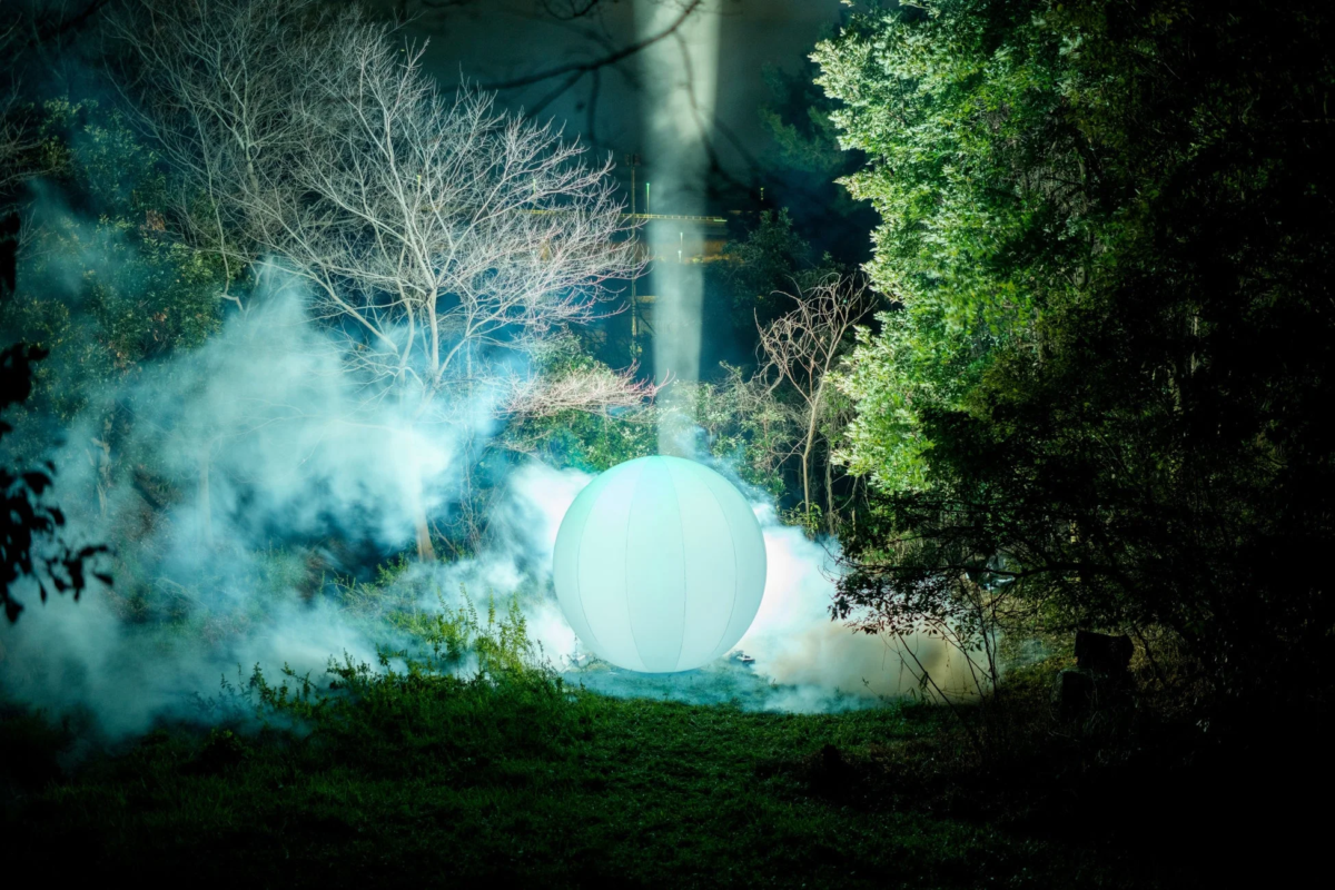 夜の森に浮かぶ光る球体のアートインスタレーション